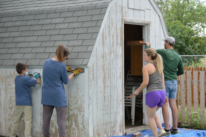 Volunteers worked on scraping old paint off of Kayleen Nichols' shed in her backyard as part of Englewood's Day of Service on June 18, 2022.